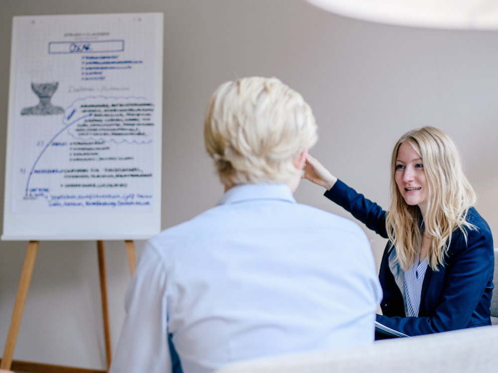 Foto: Schüler spricht mit Beraterin über Flipchart mit Empfehlungen