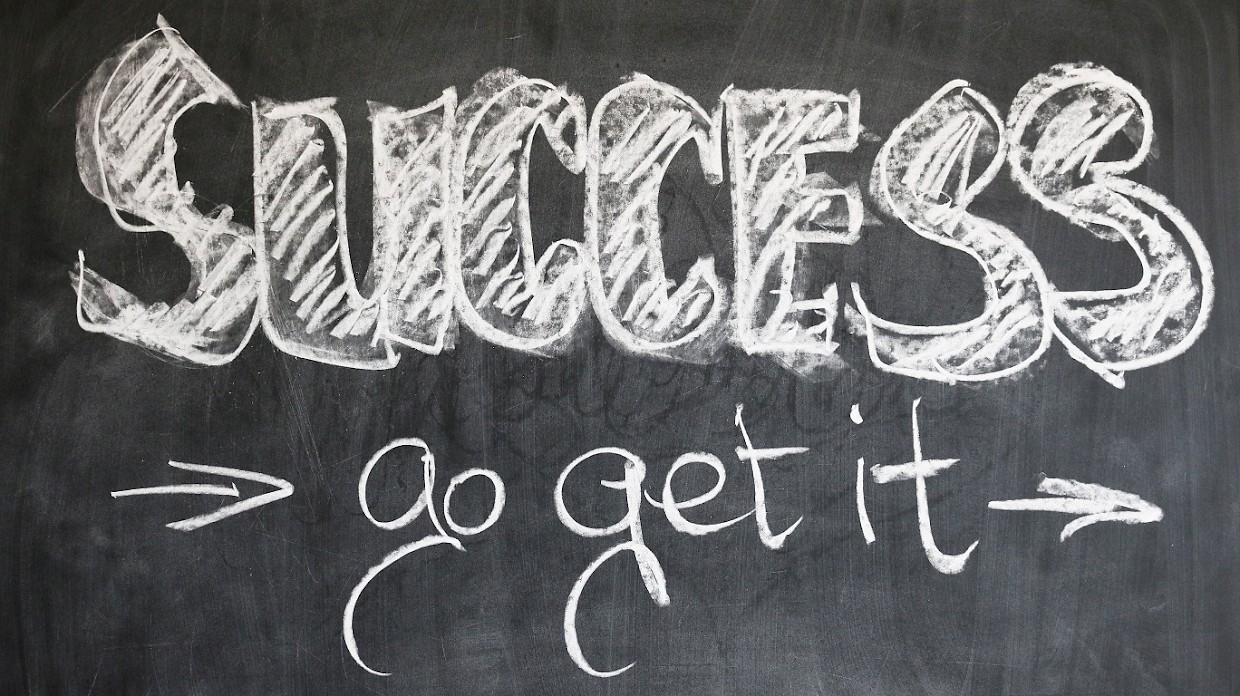 Auf einer Tafel steht mit Kreide geschrieben "Success: go get it"