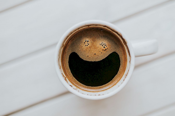 Tasse Kaffee mit einem lachenden Gesicht