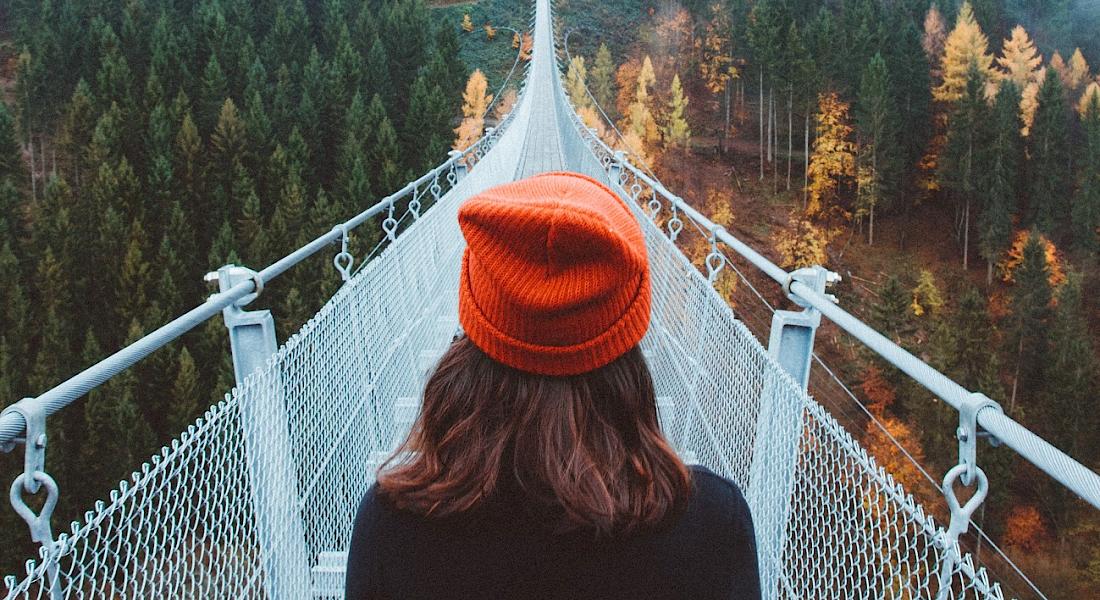 Junge Frau steht am Anfang einer großen Brücke