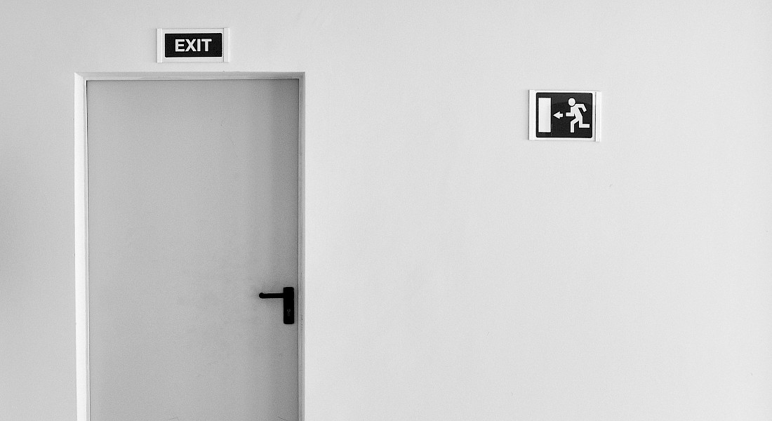 Eine Tür vor einer weißen Wand mit einem "Exit"-Schild darüber
