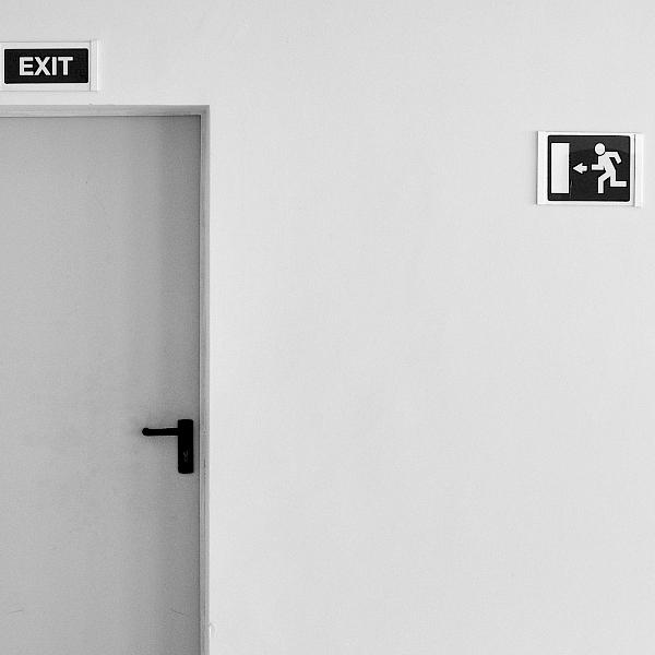 Eine Tür vor einer weißen Wand mit einem "Exit"-Schild darüber
